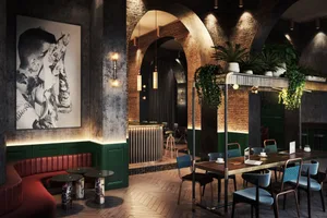Industrial-style cafe interior with exposed brick walls, concrete floors, and potted plants.