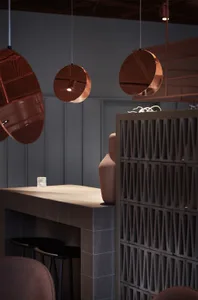Modern restaurant interior with metal counter and round lighting fixtures