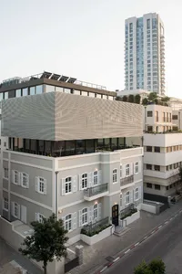A modern building with concrete exterior, metal elements, and large windows.