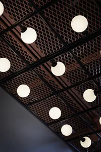 A modern, industrial-style ceiling grid with spherical light fixtures.