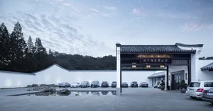 Front entrance to a building with a concrete and white color scheme, featuring a traditional canopy.