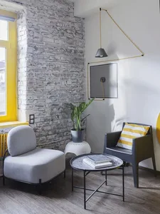 Modern, industrial-styled living room with exposed concrete and brick walls, featuring minimalist furniture.