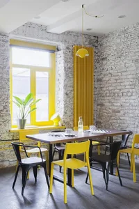 A modern industrial restaurant interior with a yellow brick wall