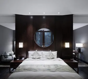 A minimalist bedroom with a bed, nightstands, and a round window.