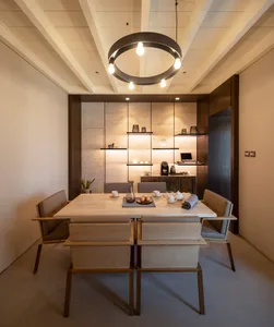 A modern dining room with a stone table and chairs, minimalistic design, and warm lighting.
