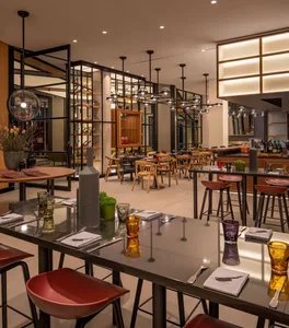 Modern industrial restaurant interior with metal, wood, and leather elements.