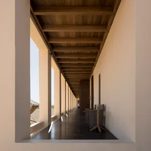 An image of a modern interior with wooden hallways and columns.