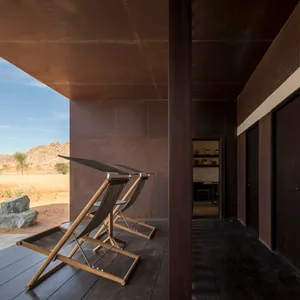 Rustic residential architectural space featuring wooden flooring and dark wood walls.