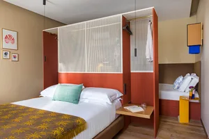 Modern minimalist bedroom featuring a metal-framed wooden bed, a foldable desk, and a small side table.