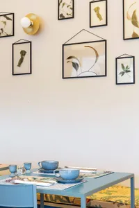Minimalist dining room featuring ceramic tableware on a blue table.