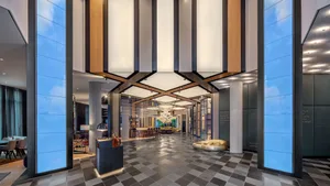 Modern hotel lobby with glass, metal, concrete, and wood elements