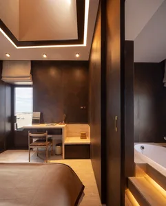A modern minimalist bedroom featuring metallic, wood, and stone materials.