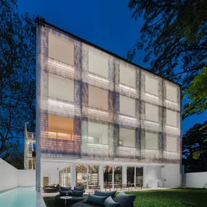 A modern residential building featuring a combination of glass and metal materials.