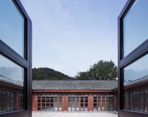 A traditional Chinese building with wooden panels and windows made of wood and cement.