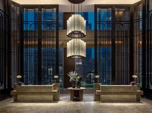 Modern hotel lobby with concrete walls, glass doors, and metal accents.