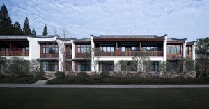 Modern residential building with white painted walls, concrete flooring, and roof tiles.