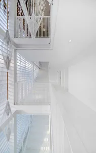 A minimalist white staircase with white railings in a modern architectural setting.