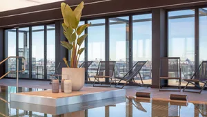 Modern interior space with concrete elements and lounge chairs.