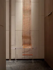 A wall-mounted acrylic table designed with metal wire for an industrial aesthetic.