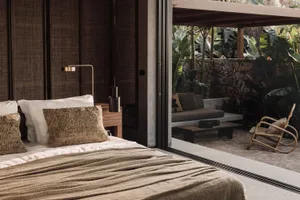 Minimalist bedroom with natural textile accents, showcasing sleek design and cozy elements.