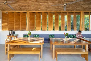 Interior design of a modern cafe bar with wooden furniture and open shutters.