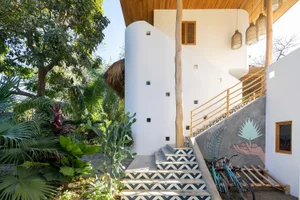 Modern house with stucco exterior and tiled steps leading to the entrance.