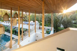A modern, open-air residential space featuring wood materials and natural light.