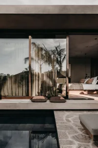 Modern minimalist bedroom featuring concrete and glass materials.