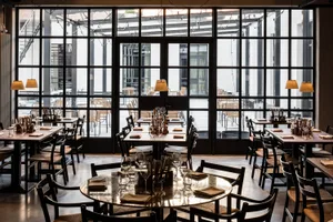 Modern restaurant interior with glass walls and open design layout.