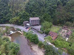 Aerial view of a vacation hotel surrounded by lush greenery, with brick and concrete buildings and wooden accents.