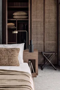A bedroom featuring bamboo wooden elements, including a bed with bamboo headboard and woven bamboo pillow, and a bedside tabl