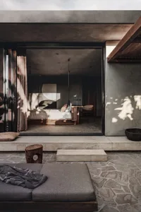 Minimalist bedroom with concrete walls and a bed.