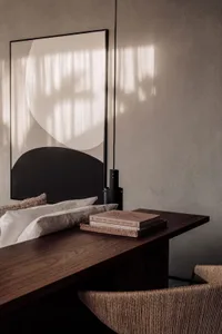 Modern minimalist living space with a textured paper-covered worktable and a large abstract artwork featuring geometric shape