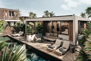Modern patio area with concrete floor and wood furniture, featuring a pool surrounded by tropical plants.