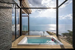 Modern bathroom overlooking the sea with a glass wall.
