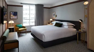 A well-designed, minimalist hotel room featuring modern furniture and textured fabrics.