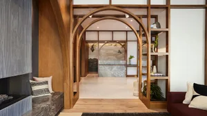 A modern interior design featuring wooden archways, with a cozy seating area and decorative elements.