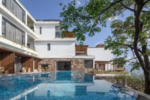 Modern residential exterior with concrete, stone, and glass elements.