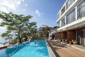 Modern resort with glass floor tiles and outdoor pool area, featuring a contemporary hotel design.