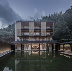 Modern residential building with wooden facade and reflection in water body.