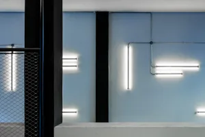 A minimalist interior design featuring concrete walls and lighting fixtures.