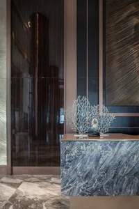 A luxurious reception desk made of grey marble with a crab sculpture on top.