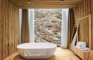 A minimalist bathroom featuring stonework materials and a window with a scenic view of a rocky landscape.