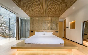 Modern minimalist bedroom featuring bamboo flooring, a platform bed, and a bamboo wall decor.
