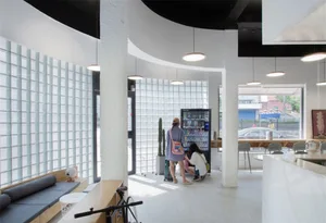 A minimalist coffee shop interior featuring glass block panels and clean lines.