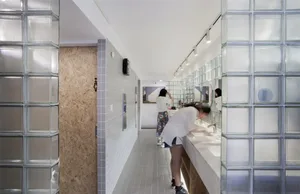 A minimalist public bathroom with glass blocks on the walls.
