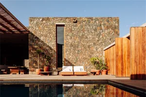 Concrete patio with two lounge chairs and potted plants.