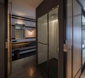 Modern bathroom with white tiled walls and floor, black accents, and a glass shower enclosure.