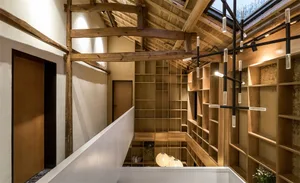 A modern bookshelf library with wooden shelves and exposed wooden beams on the ceiling.
