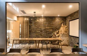 Industrial-style conference room with stone walls and wooden furniture.